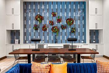 A dining room with a wooden table surrounded by chairs and a blue couch.